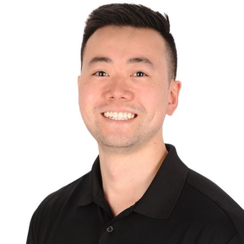 Professional headshot of Dr. Yuki Gomi, a Synergy Rehab team member, wearing a branded black polo shirt.